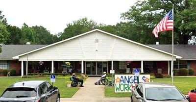 Exterior view of Roswell Nursing & Rehab Center with residents outside.