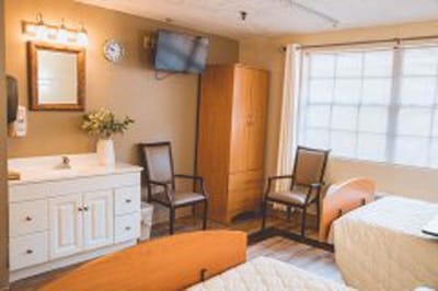 Cozy resident room with two beds and chairs