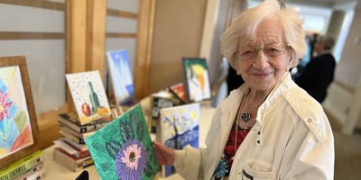 Resident displaying artwork at a social event