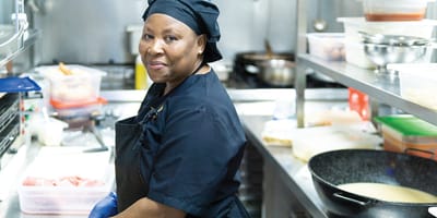 Staff member preparing food in kitchen area