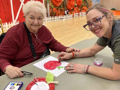 Resident and staff engage in a creative activity.