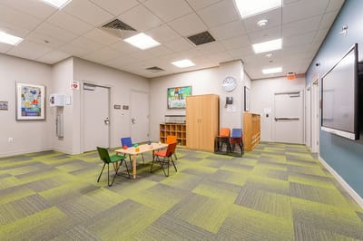 Interior activity room with seating and artwork.