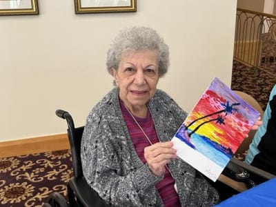 Resident proudly displaying an art project.
