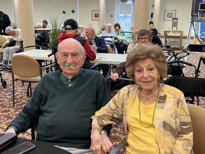 Two residents enjoying a festive event at the facility.