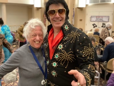 Resident joyfully celebrates with an Elvis impersonator.