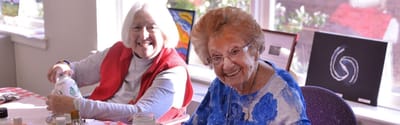 Two smiling residents engaged in an art activity.