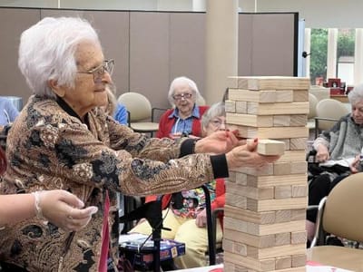 Residents enjoying a game of Jenga in a common area.