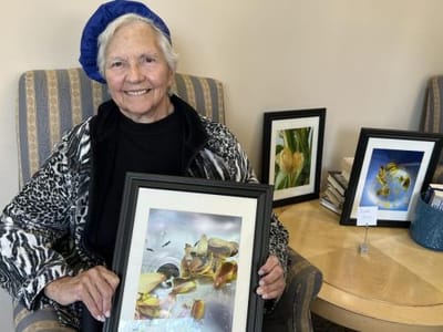 Resident proudly displays her artwork in common area.