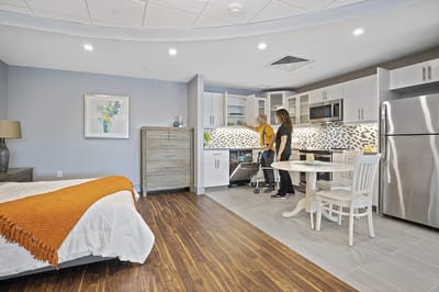 A modern assisted living room with two residents.