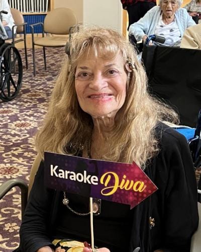 Resident enjoying a karaoke activity with a sign