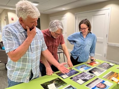 Three residents engaging with photos on a table.