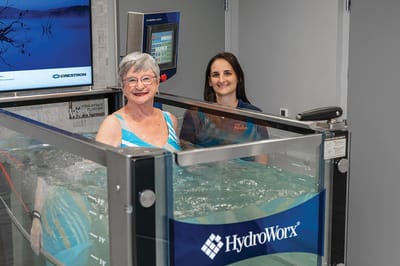 Resident and staff member in a therapeutic pool session.