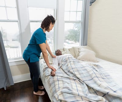 Staff assisting a resident in their room