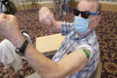 Senior resident showing vaccination evidence.