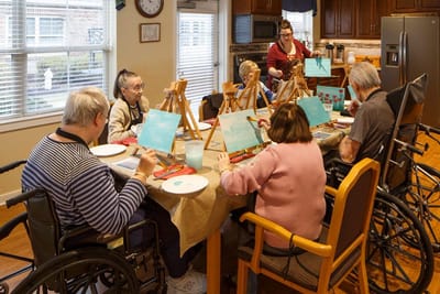 Residents engaged in a painting activity inside the facility