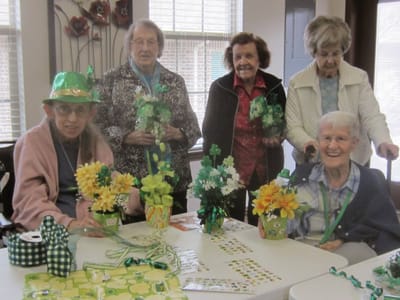 Residents engaged in a floral arrangement activity.
