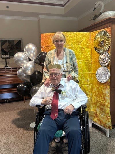 Celebration with residents and staff in a decorated common area.