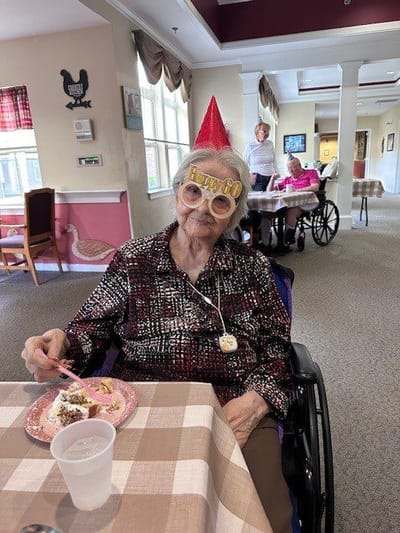Resident celebrating with party hat and cake