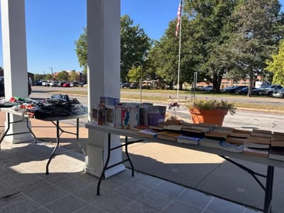 Outdoor event with tables displaying items.