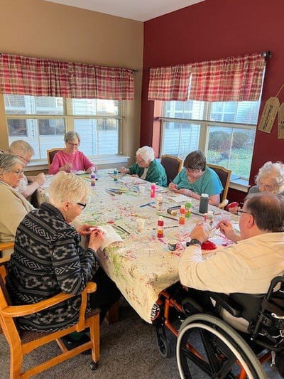 Residents and staff engaged in an arts and crafts activity.