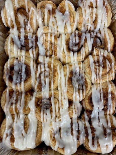 A tray of iced cinnamon rolls ready for serving.