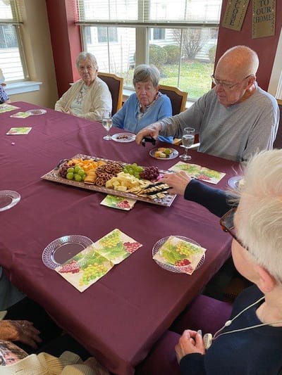 Residents enjoying a meal together at a dining room table.