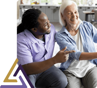 Staff and resident sharing a joyful moment indoors.