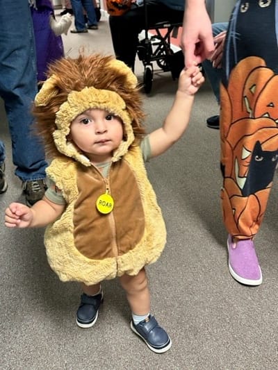 Child in a lion costume in a hallway