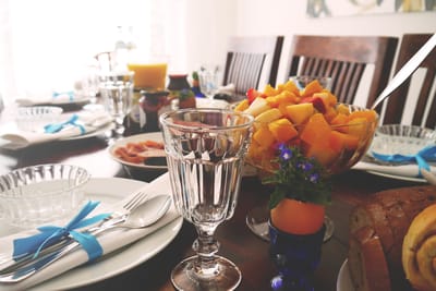 A beautifully set dining table with fruit and drinks