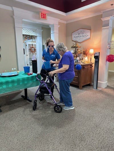 A staff member assisting a resident in a common area.