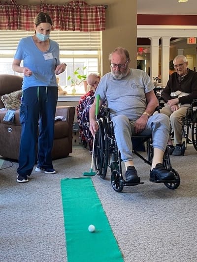 Residents participating in an indoor putting activity