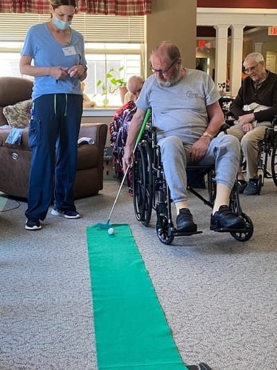 Residents participating in an indoor putting activity.