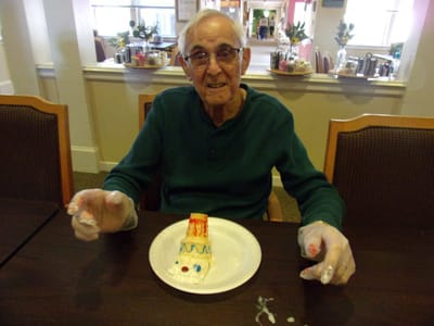 Resident celebrating with a decorated cake.