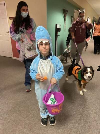Children and pets in costumes during an indoor event