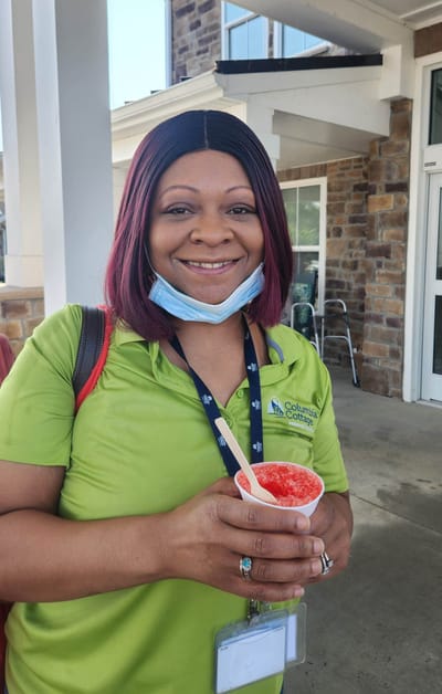 Staff member serving a treat outside the facility.