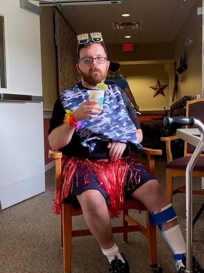 Resident enjoying a festive activity with a drink