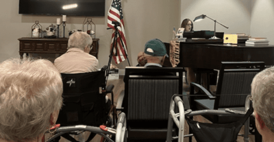 Residents enjoying music activity in common area.