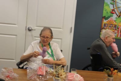 Residents enjoying activities with crafts and treats.