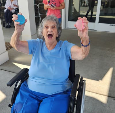 Older adult enjoying an activity with colorful objects.