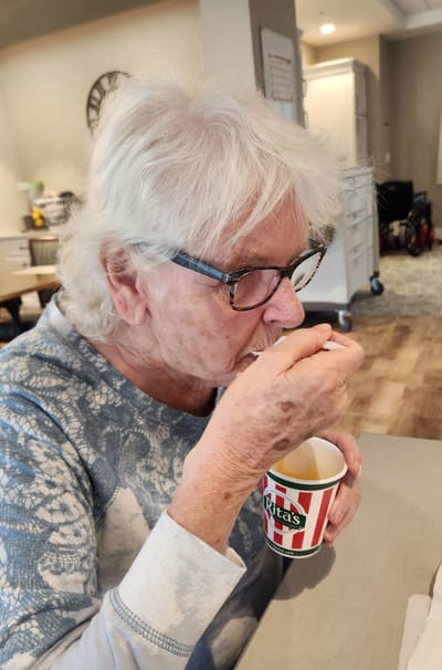 Senior woman enjoying ice cream indoors