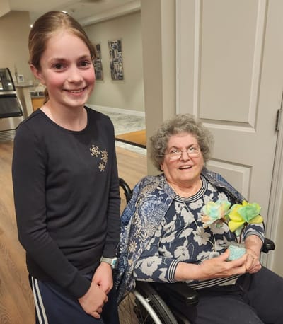 A young girl and a resident smiling together indoors.