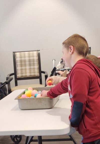 Child engaging in an activity with colorful balls.