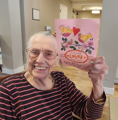 Elderly woman holding a handmade card.