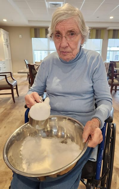 Resident measuring sugar in a bright common area.