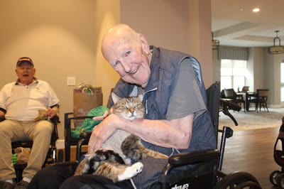 Resident lovingly holding a cat in a common area