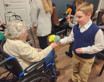 Resident receiving a flower from a child