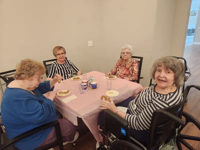 Four residents enjoying snacks together at a table.