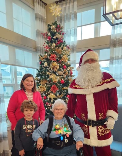 Resident celebrating with Santa and family