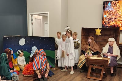 Children performing in a holiday-themed play indoors.
