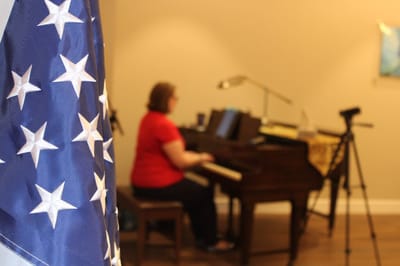 A resident playing piano with an American flag in view.